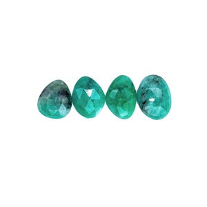 May include: Four teal green faceted gemstone beads, each with a slightly different shape and pattern.