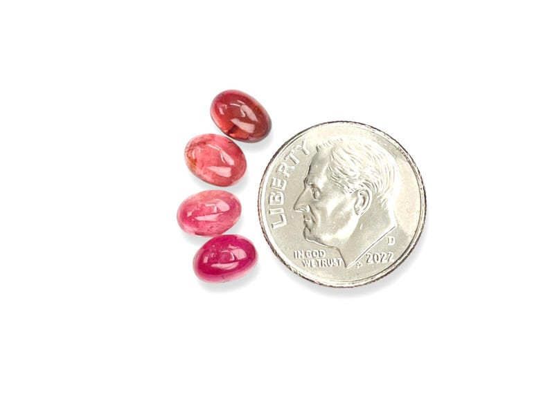 Pink tourmaline smooth cut oval cabochon stones.  Four gemstone cabochons size 7 x 5 mm pictured next to a dime for size reference.