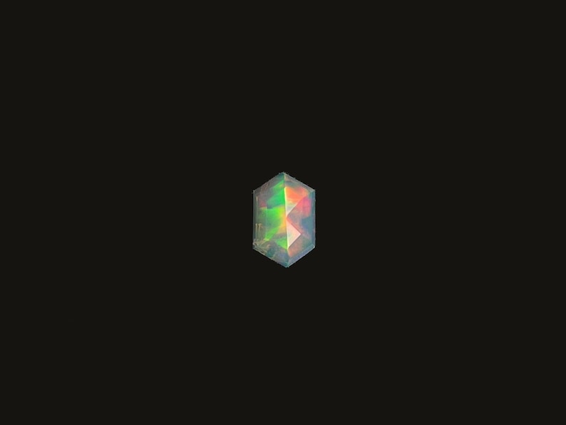Ethiopian opal prism cut elongated hexagon gemstone cabochon.  Single rose cut cabochon size 10 x 6.6 mm seen from the top on a black background.