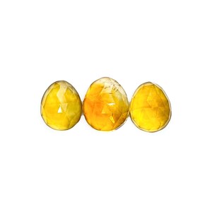 Yellow citrine gemstone cabochons size 11 to 12 mm.  Three rose cut cabochon stones seen from the top.