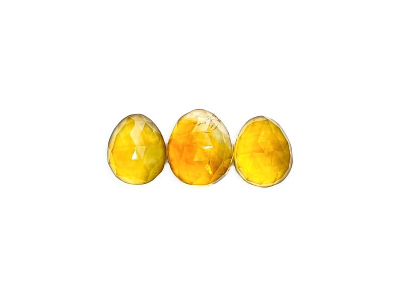 Yellow citrine gemstone cabochons size 11 to 12 mm.  Three rose cut cabochon stones seen from the top.