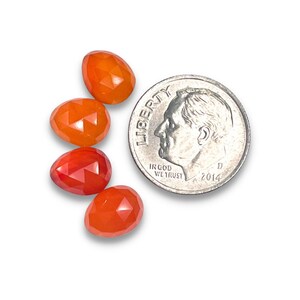 Four red-orange carnelian gemstone cabochons.  Rose cut cabochon stones size 8.5 to 9.5 mm are pictured next to a dime for size reference.