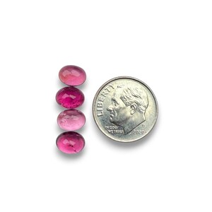 Pink tourmaline smooth cut oval cabochon stones.  Four gemstone cabochons size 8 x 6 mm pictured next to a dime for size reference.