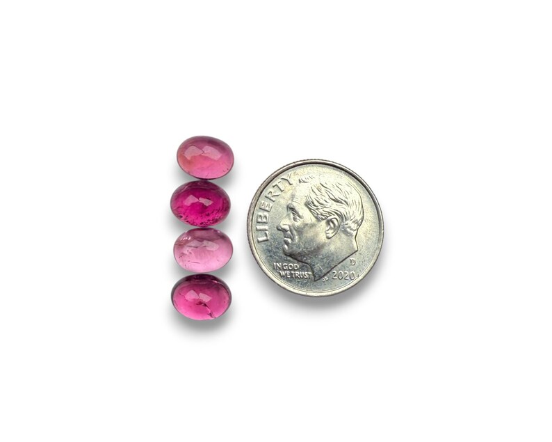 Pink tourmaline smooth cut oval cabochon stones.  Four gemstone cabochons size 8 x 6 mm pictured next to a dime for size reference.