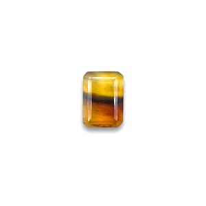May include: A yellow, brown, and black gemstone with an emerald cut.