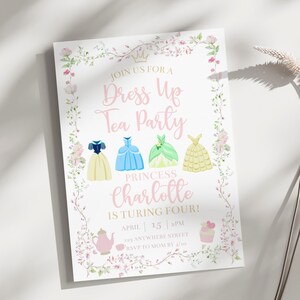 Puede incluir: Una invitaci&oacute;n blanca con texto rosa y detalles florales. La invitaci&oacute;n dice "&Uacute;nete a nuestra Fiesta de T&eacute; de Disfraces" y presenta ilustraciones de vestidos de princesa. El texto tambi&eacute;n incluye "&iexcl;La Princesa Charlotte cumple cuatro a&ntilde;os!"