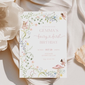 May include: A pale pink birthday invitation with floral and fairy illustrations. The text reads "Gemma's fairy first birthday" with the date, time, and address. The design includes a mushroom and fairy illustrations.