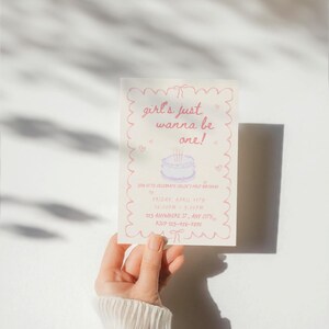 May include: Pink and white birthday party invitation with a hand-drawn illustration of a cake with candles. The text reads "girl's just wanna be one!" and includes details for the party, such as the date, time, and location.