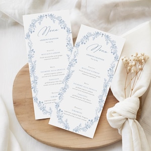 May include: Two baptism menu cards with a floral design in light blue. The cards feature the word "Menu" in elegant script, the name "Andrew's Baptism" and the date. The menu includes starters, main courses, and desserts.