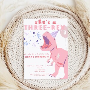 Puede incluir: Invitaci&oacute;n de fiesta de cumplea&ntilde;os con tem&aacute;tica de dinosaurios, con un T-Rex rosa y morado con un gorro de fiesta. El texto dice "she's a THREE-REX" y los detalles de la fiesta de Emma.