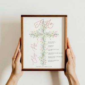 Puede incluir: Una impresión enmarcada con un diseño de cruz floral y las palabras "I Am" en escritura rosa. El nombre "Elyse Rose" está escrito en escritura rosa. El texto adicional incluye "Beautiful", "Chosen" y "Baptized October 12, 2025."