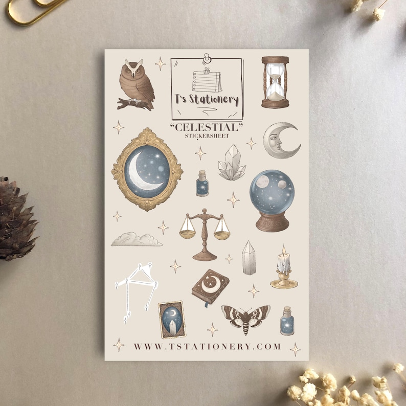 Puede incluir: Una hoja de pegatinas con tem&aacute;tica celestial, con ilustraciones de un b&uacute;ho, un reloj de arena, una luna, una bola de cristal, una balanza y una polilla. Tambi&eacute;n est&aacute; presente el texto "Celestial" y "T's Stationery". El sitio web www.tstationery.com est&aacute; en la parte inferior.