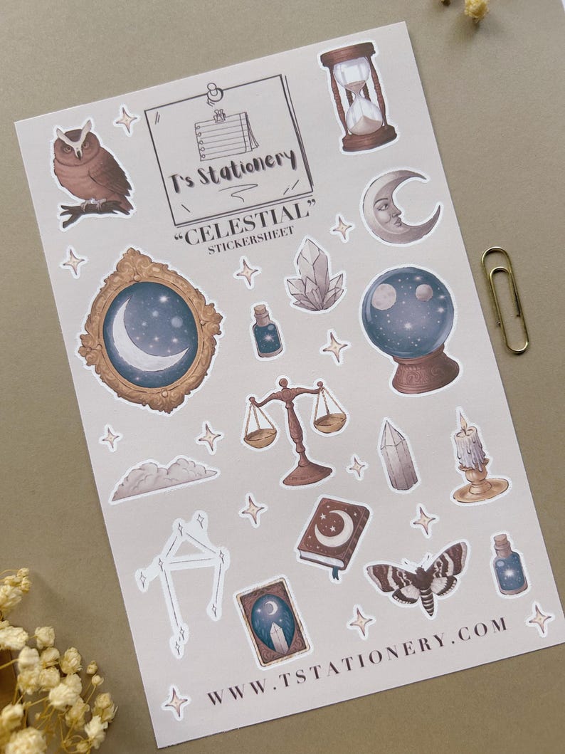 Puede incluir: Una hoja de pegatinas con ilustraciones de tem&aacute;tica celestial. Incluye un b&uacute;ho, un reloj de arena, una luna creciente, una bola de cristal, una balanza y una polilla. Tambi&eacute;n se ve el texto "T's Stationery", "Celestial" y www.tstationery.com.