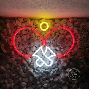 May include: Neon sign featuring a ping pong paddle design with a red outline and a white handle. A yellow circle represents the ball. The sign is mounted on a wall of white stones. The text "NEON SIGN CLUBS" is in the lower right corner.
