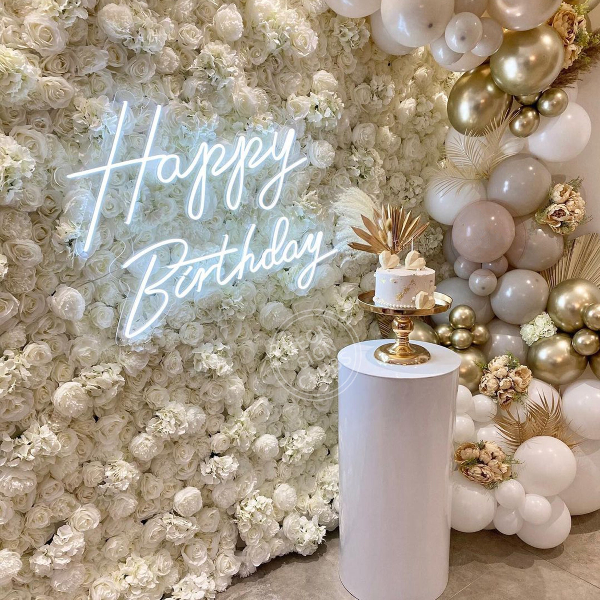 Elegant birthday backdrop with white roses, gold balloons and a cake