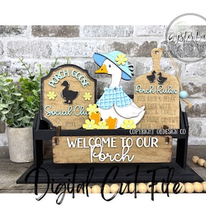 May include: A wooden porch decoration featuring a goose wearing a hat and shirt, with signs that read "Porch Goose Social Club" and "Welcome to Our Porch." The decoration includes yellow flowers and a cutting board with "Porch Rules."