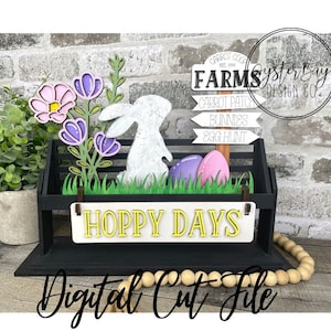 May include: A black wooden shelf with a white sign that says "Hoppy Days" and a bunny rabbit cutout. The shelf is decorated with a flower arrangement, Easter eggs, and a sign that says "Carrot Cool Farms" with arrows pointing to "Carrot Patch", "Bunnies", and "Egg Hunt".