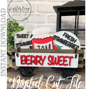 May include: A wooden wagon with wheels, filled with wooden signs that say "Sweet Strawberries", "Fresh Strawberries", and "Jam". The wagon has a white sign on the front that says "Berry Sweet" in red letters.
