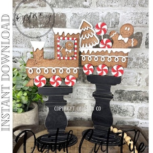 May include: Two gingerbread train decorations with red and white peppermint wheels and candy accents. The train cars are brown with white frosting details and sit atop black pedestals. The text "Instant Download" and "Digital Cut File" are visible.