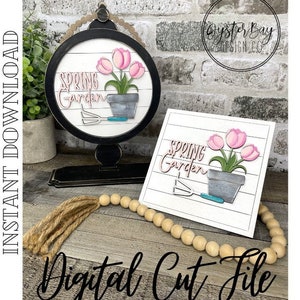 May include: A digital cut file design featuring a spring garden theme. The design includes a round sign with the text "Spring Garden" and a flower pot with pink tulips. The design also includes a square sign with the same text and a flower pot with pink tulips. The design is perfect for creating a spring-themed craft project.
