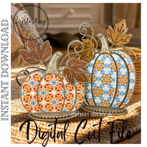 May include: Two decorative wooden pumpkins with fall leaf accents. One pumpkin features an orange and white geometric pattern, the other a blue and orange floral design. The image includes the text "Digital Cut File".