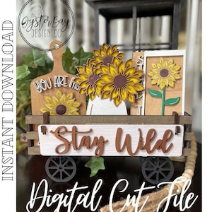 May include: A wooden wagon with black wheels and a white sign that says "Stay Wild". The wagon is decorated with sunflowers and a wooden sign that says "You Are My Sunshine".