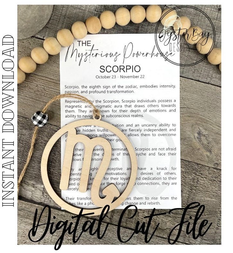May include: A wooden cutout of the astrological symbol for Scorpio, with the text "The Mysterious Powerhouse Scorpio" and "October 23 - November 22" printed on a white card behind it. The text describes Scorpio as the eighth sign of the zodiac, embodying intensity, passion, and profound transformation.