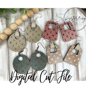 Puede incluir: Un conjunto de seis pendientes de madera con patrones geométricos. Los pendientes son de varios colores, incluyendo rojo, verde y marrón. Los pendientes se muestran sobre una superficie de madera con una guirnalda de cuentas de madera.