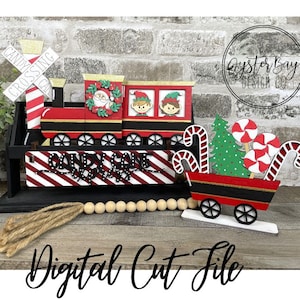 May include: A red and black wooden train with a candy cane theme. The train has a sign that says "Candy Cane Express" and a candy cane crossing sign. There is a red and black wagon with a Christmas tree and candy canes. The train and wagon are on a wooden surface with a burlap rope and wooden beads.