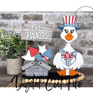 May include: A patriotic wooden goose figurine wearing a Uncle Sam hat and holding firework-themed decorations. A sign reads "Fire Quackers" next to a basket of star-shaped fireworks. The design is perfect for Independence Day.