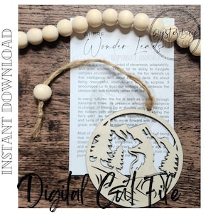 May include: A wooden fox-themed ornament with a mountain and tree design. The ornament hangs from a twine loop and features the text "Digital Cut File". A paper with text is behind the ornament.