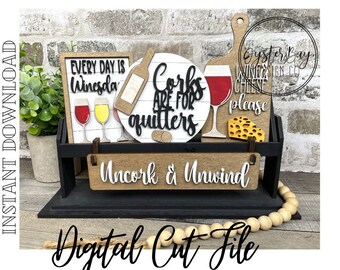 May include: A wooden sign with the text "Uncork & Unwind" and a variety of other signs with wine and cheese themes. The signs are displayed on a black shelf with a wooden base and a string of wooden beads.
