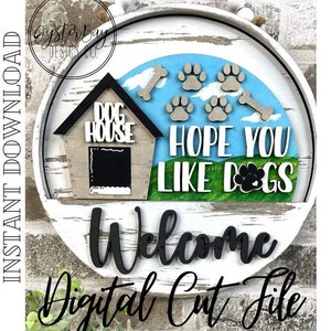 May include: A round wooden sign with a white background and a distressed finish. The sign features a black silhouette of a dog house with the words "Dog House" above it. There are paw prints and bones scattered around the dog house. The words "Hope You Like Dogs" are written in white on a green background. The word "Welcome" is written in black below the dog house. The sign is a digital cut file.