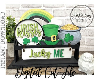 May include: A set of five St. Patrick's Day themed wood cutouts. The cutouts include a green shamrock, a pot of gold, a leprechaun hat, a sign that says "Lucky Me", and a circle that says "Irish Kisses".