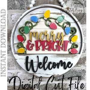 Puede incluir: Un letrero redondo de madera blanca con las palabras "Merry & Bright" en dorado y rojo, y "Welcome" en negro. Luces navideñas de colores y el texto "Digital Cut File" también están presentes.