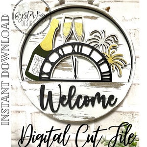 Op de afbeelding: Een rond bord van wit hout met een zwarte wijzerplaat, een champagnefles, glazen en vuurwerk. Het bord zegt "Welkom" in zwarte letters.