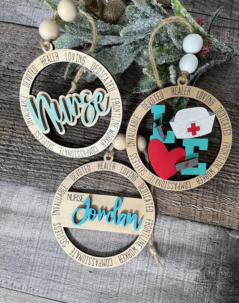 Pu&ograve; includere: Tre ornamenti in legno con un tema infermieristico blu turchese. Gli ornamenti sono rotondi e hanno le parole "Infermiera", "Amore" e "Jordan" scritte su di essi. Gli ornamenti sono decorati con parole come "compassionevole", "altruistico", "inestimabile", "lavoratore in prima linea", "dedicato", "guaritore" e "amorevole".