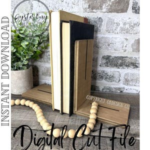May include: A stack of books between two wooden bookends. The bookends are light brown with a slot for the books. A strand of wooden beads is in front of the books. The words "Digital Cut File" are written in a script font.