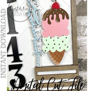 May include: A digital cut file for a wooden sign featuring a large ice cream cone with a cherry on top, a blue and white "Sweet" sign, and the numbers 1, 4, and 3. The sign is on a wooden background.