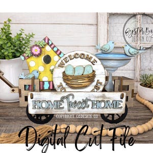 May include: A wooden decorative cart featuring a birdhouse, bird bath, and a sign reading "HOME Sweet HOME". The birdhouse is yellow with pink and blue details. The cart has black wheels and is decorated with small blue birds.