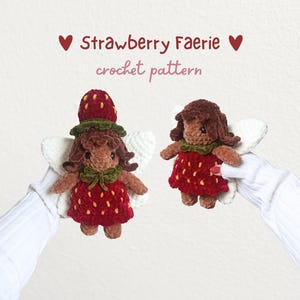 May include: Two crocheted dolls featuring brown skin, dark brown hair, and red strawberry-themed dresses with yellow seeds. One doll wears a strawberry hat, and both have white wings. Text reads: ♥ Strawberry Faerie ♥ crochet pattern.