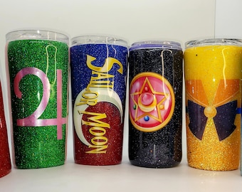 May include: Six stainless steel tumblers with glitter and various Sailor Moon character designs. The tumblers are red, green, red, black, yellow, and blue.