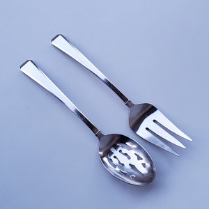 May include: A silver slotted spoon and a silver fork, both with a polished finish.