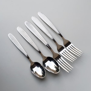 May include: A set of five silver utensils, including two spoons and three forks. The spoons have a rounded bowl and a long handle. The forks have four tines and a long handle.
