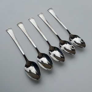May include: Set of six silver spoons with ornate handles. The spoons have a polished finish and are arranged in a row.