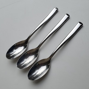 May include: Three silver spoons with rounded bowls and long, slender handles.