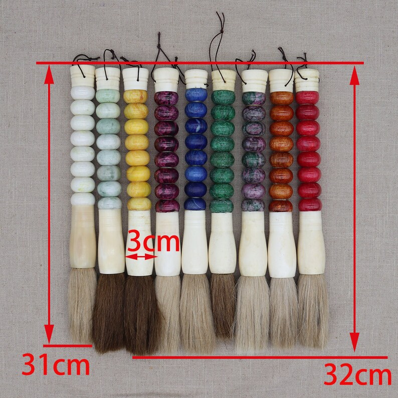 K&ouml;nnte beinhalten: Set mit 8 Kalligraphie-Pinseln mit bunten Griffen. Jeder Griff ist aus einem anderen Steintyp gefertigt und hat eine Schnur. Die Pinsel sind 31 cm lang und der Pinselkopf ist 3 cm breit.
