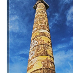 May include: A tall, yellow column with black painted scenes depicting historical events. The column is against a bright blue sky with white clouds. The text on the column reads "INDIANS GREET", "MT. HOOD OCT 1792", "MAY 11 1792", and "GRAY FINDS", "WHITE MAN CAME".