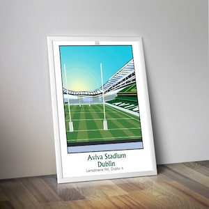 May include: A white framed illustration of Aviva Stadium in Dublin, Ireland. The stadium is shown with a green field and a blue sky. The text "Aviva Stadium Dublin Lansdowne Rd. Dublin 4" is printed below the image.