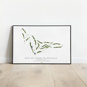 May include: A black and white print of a golf course map with green and blue details. The text "GOLF DU CHAMP DE BATAILLE" is at the bottom of the print. The text "Le Neubourg, Eure, France" and "Latitude 49.194653 / Longitude 0.904471" are also included.